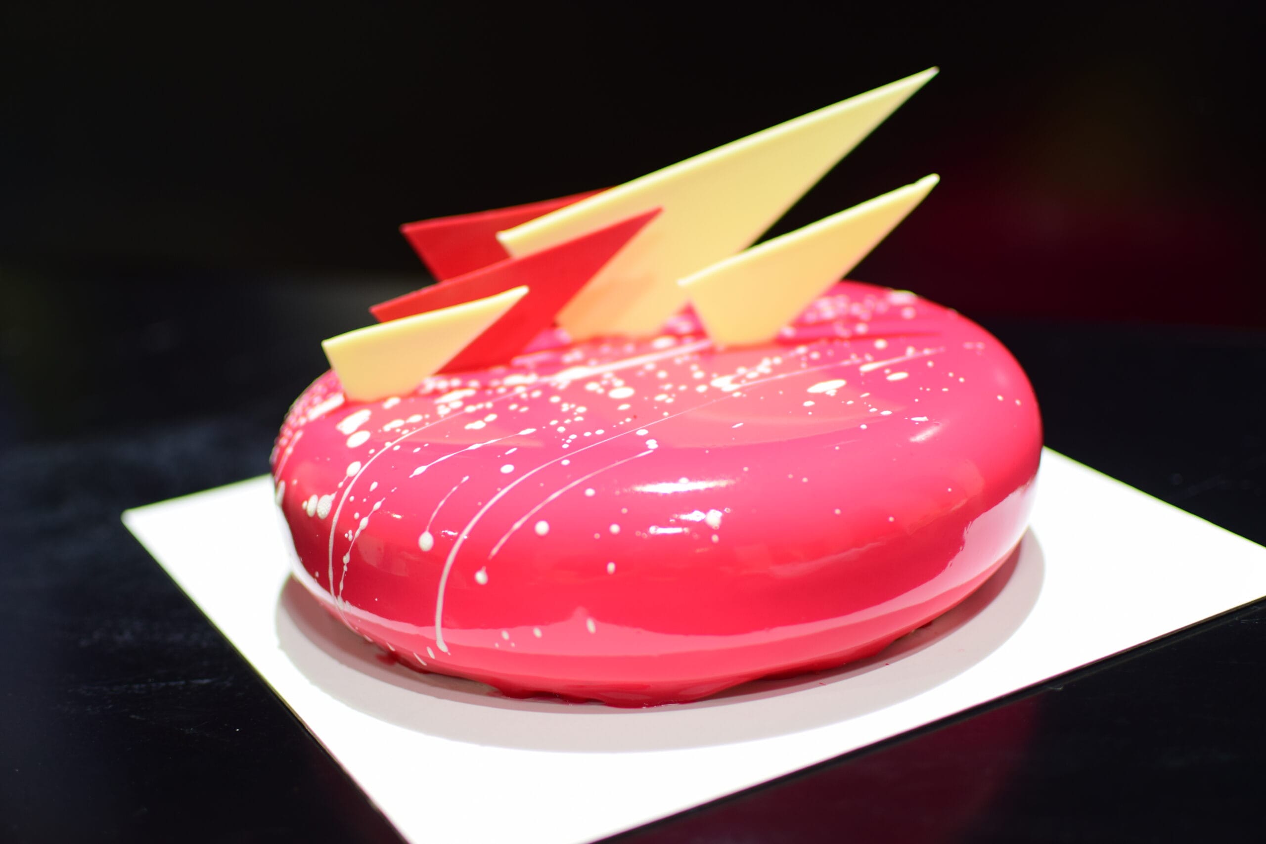 Tarta con glaseado brillante rosa y decoración contemporánea